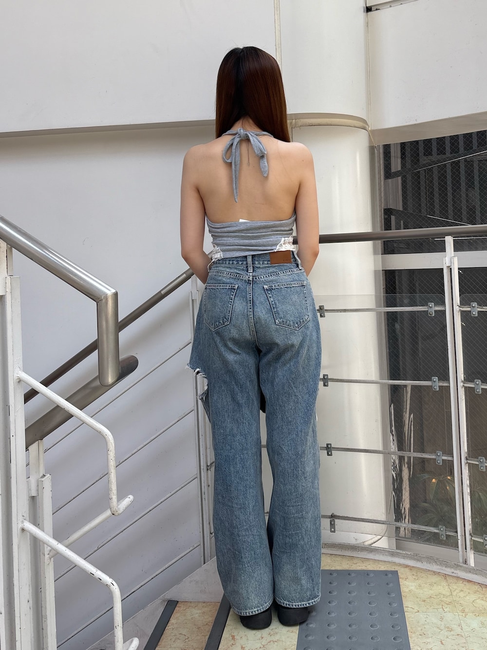 ブルー系のデニムパンツ、ブラック系のボストンバッグ、ブラック系のブーツを着用したレディースの夏コーディネートの3枚目の写真