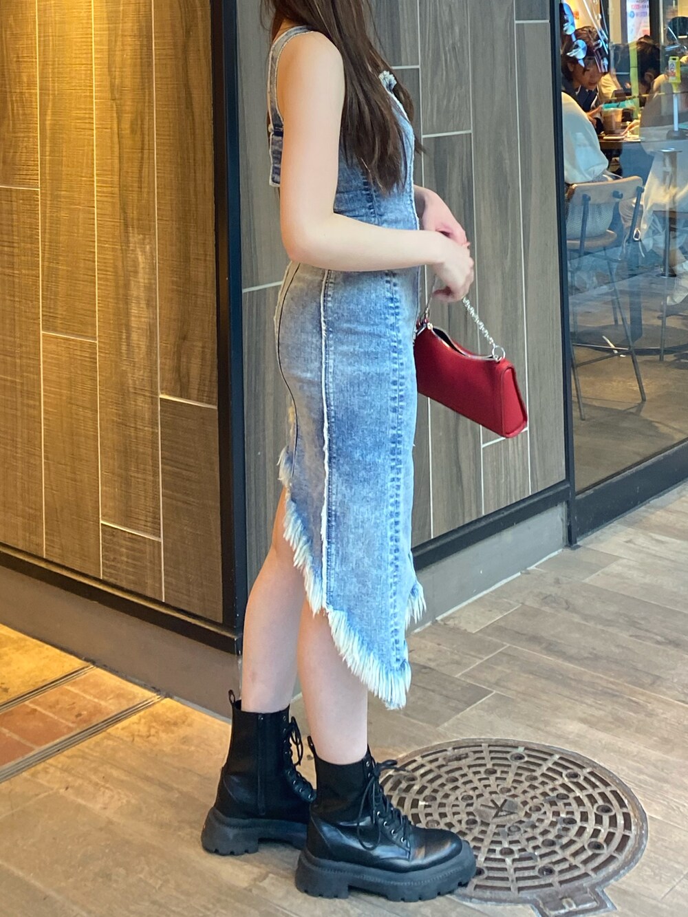 ブルー系のワンピース、レッド系のショルダーバッグ、ブラック系のブーツを着用したレディースの夏コーディネートの2枚目の写真