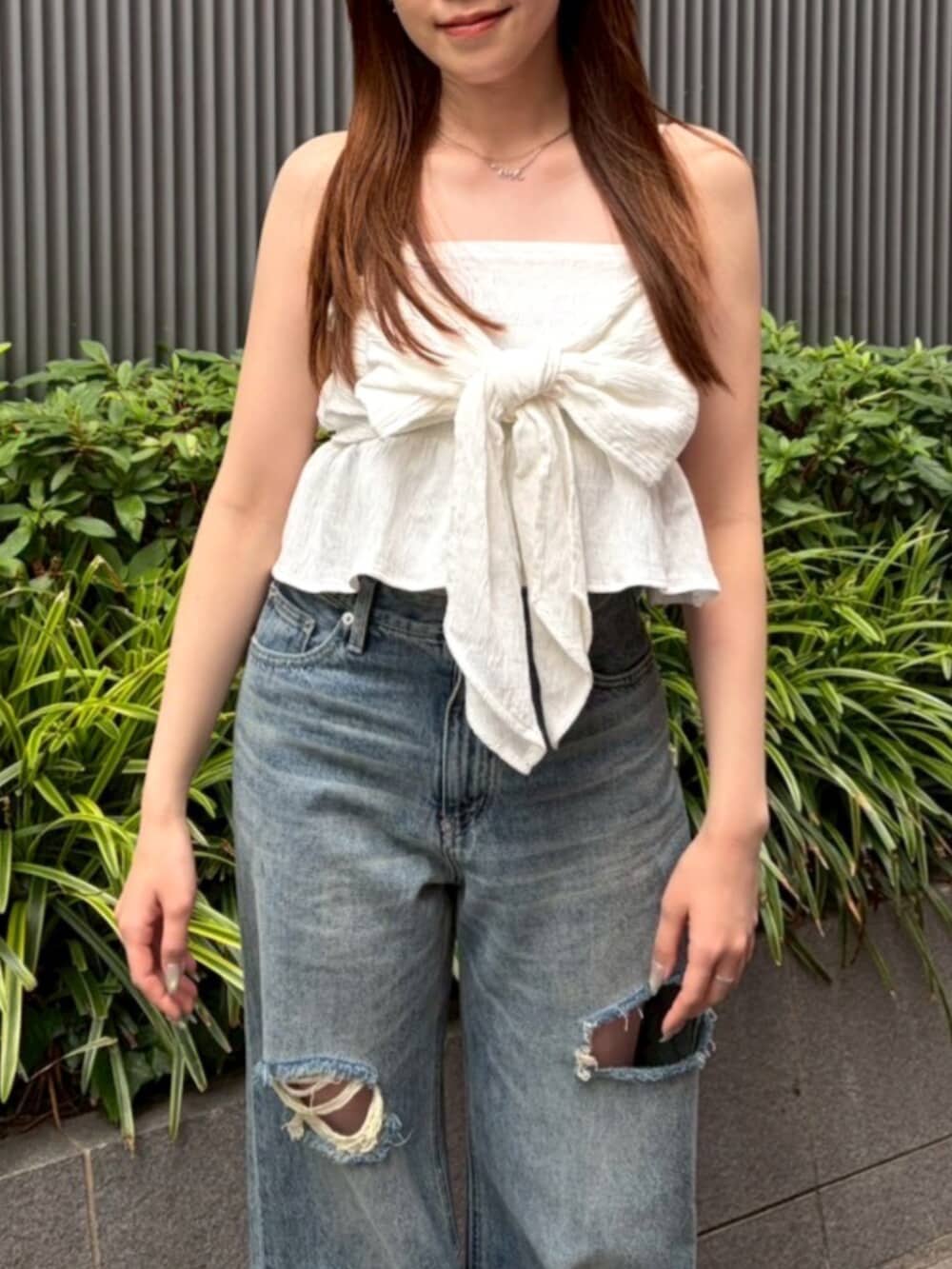 ホワイト系のキャミソール、ブルー系のデニムパンツ、ホワイト系のサンダルを着用したレディースの夏コーディネートの4枚目の写真