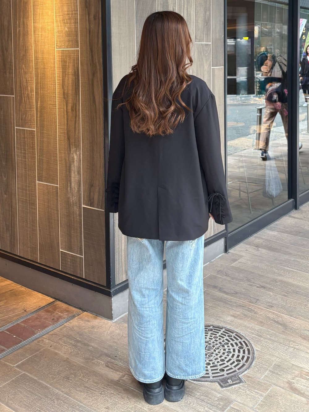 ブルー系のデニムパンツ、ブラック系のブーツ、ホワイト系のTシャツ/カットソーを着用したレディースの春コーディネートの3枚目の写真