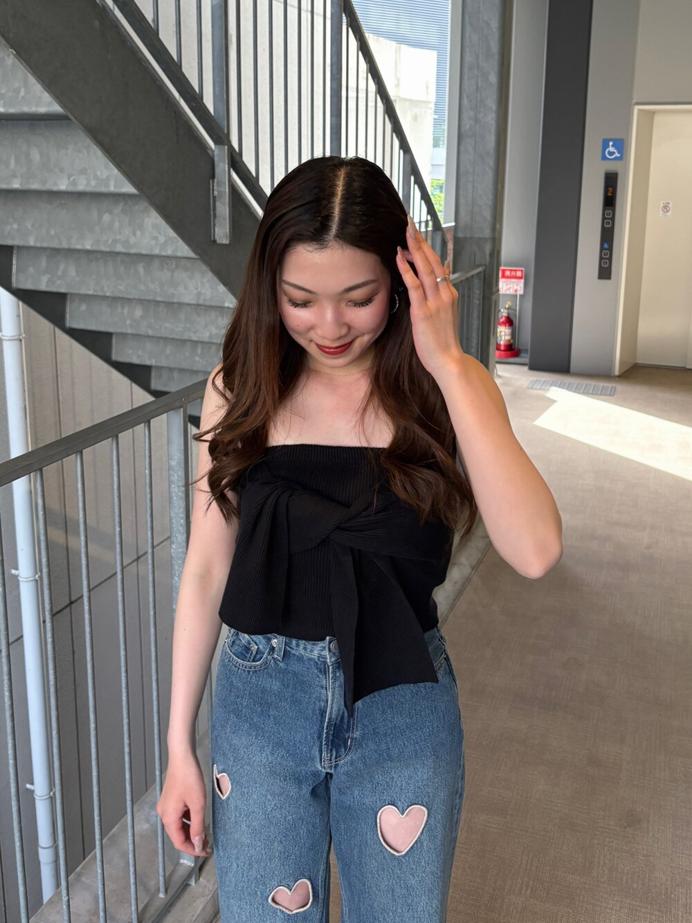 ブルー系のデニムパンツ、ブラック系のキャミソール、ブラック系のブーツを着用したレディースの春コーディネートの4枚目の写真