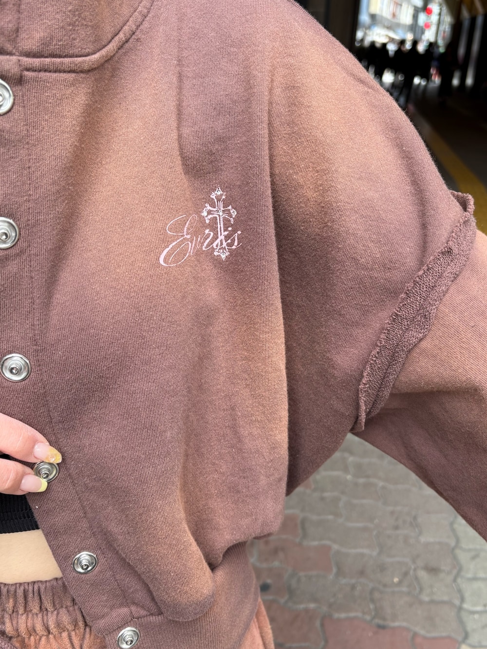 ブラウン系のスウェットパンツ、ブラック系のブーツ、ブラウン系のパーカーを着用したレディースの春コーディネートの5枚目の写真