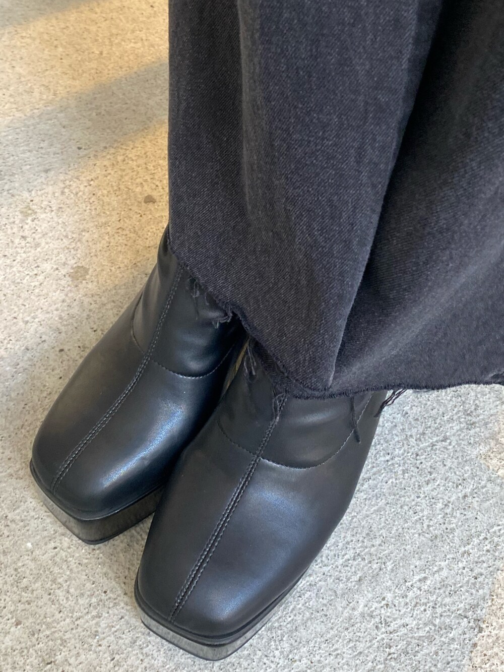 ブラック系のデニムパンツ、ブラック系のブーツ、ブラック系のライダースジャケットを着用したレディースの秋コーディネートの7枚目の写真