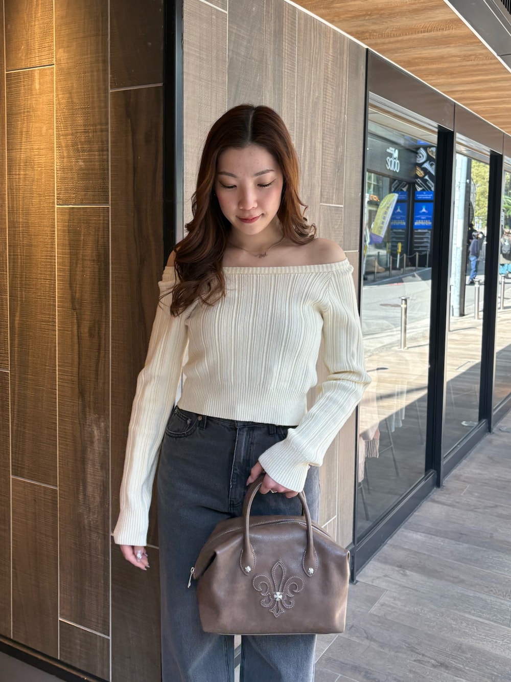 ホワイト系のニット/セーター、ブラック系のデニムパンツ、ブラウン系のボストンバッグを着用したレディースの冬コーディネートの4枚目の写真