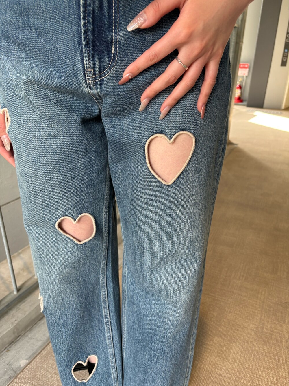 ブルー系のデニムパンツ、ブラック系のキャミソール、ブラック系のブーツを着用したレディースの春コーディネートの6枚目の写真