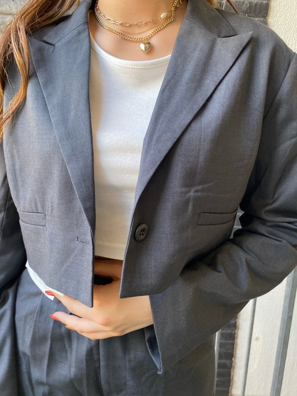 グレー系のテーラードジャケット、ホワイト系のTシャツ/カットソー、グレー系のその他パンツを着用したレディースの秋コーディネートの5枚目の写真