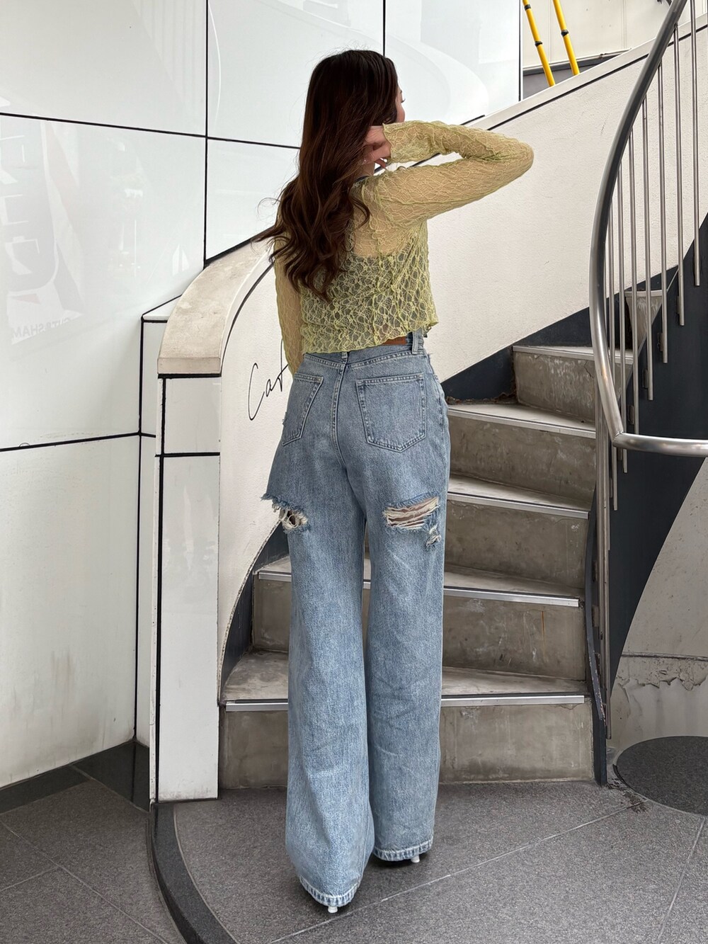 ホワイト系のパンプス、ブルー系のデニムパンツ、イエロー系のカーディガン/ボレロを着用したレディースの春コーディネートの3枚目の写真