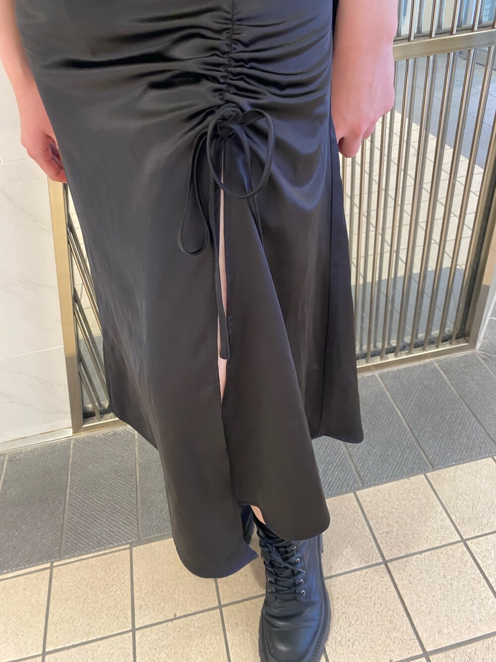 ブラック系のワンピース、ブラック系のトートバッグ、ブラック系のブーツを着用したレディースの夏コーディネートの7枚目の写真