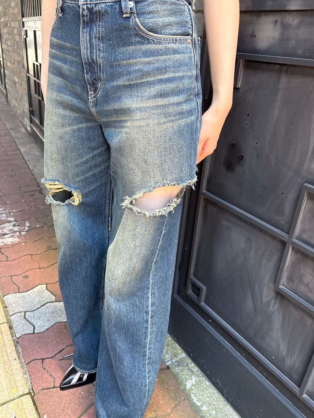 ブルー系のデニムパンツ、グリーン系のキャミソール、ブラック系のサンダルを着用したレディースの夏コーディネートの6枚目の写真