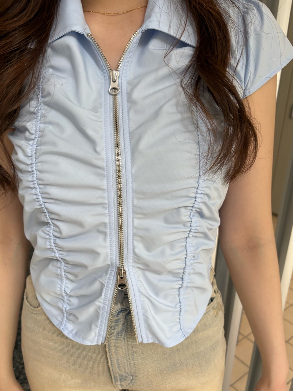 ベージュ系のデニムパンツ、ブラック系のブーツ、ブルー系のシャツ/ブラウスを着用したレディースの春コーディネートの5枚目の写真