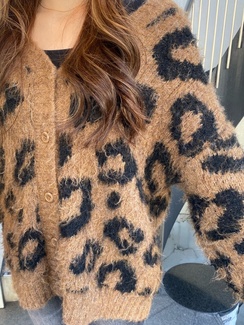 ブラック系のデニムパンツ、ブラウン系のニット/セーター、レッド系のショルダーバッグを着用したレディースの秋コーディネートの5枚目の写真