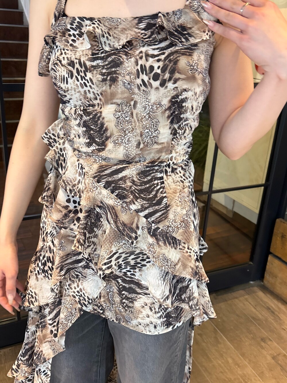 ベージュ系のワンピース、ブラック系のデニムパンツ、ブラック系のブーツを着用したレディースの夏コーディネートの5枚目の写真