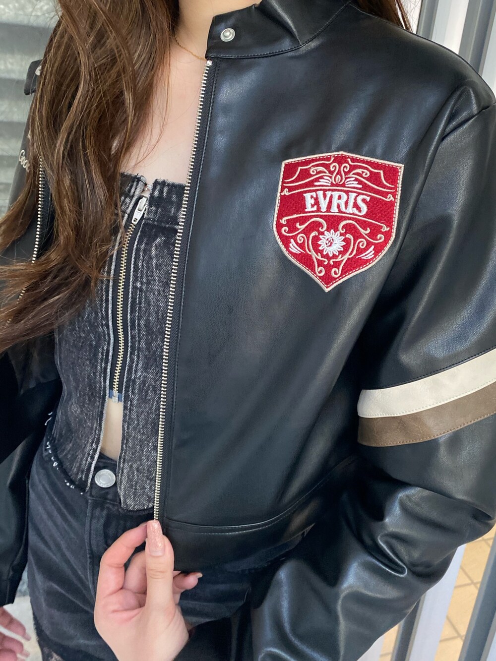 ブラック系のデニムパンツ、ブラック系のブーツ、ブラック系のライダースジャケットを着用したレディースの秋コーディネートの5枚目の写真