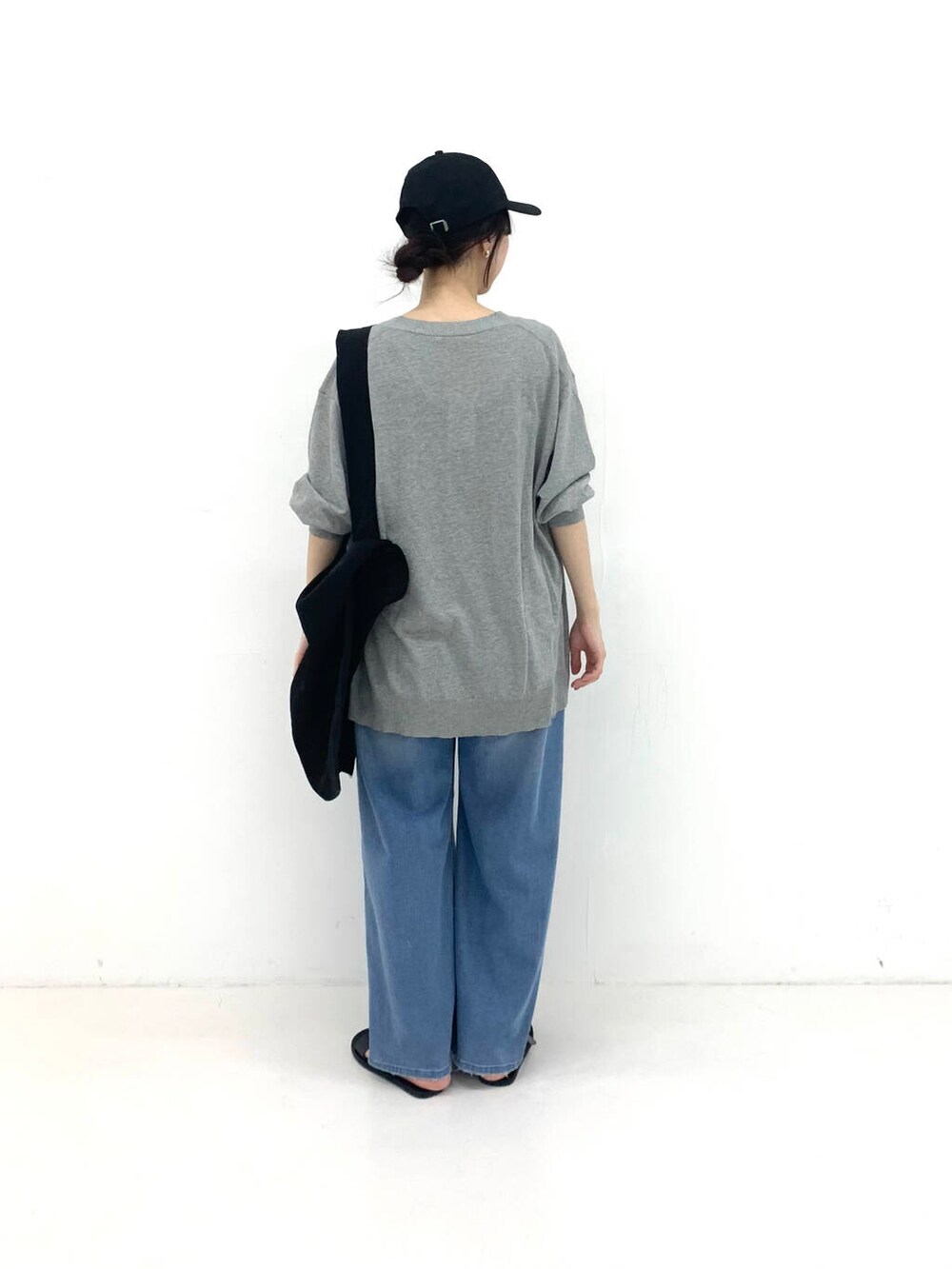 ブラック系のサンダル、ブラック系のトートバッグ、ブルー系のデニムパンツを着用したレディースの夏コーディネートの2枚目の写真