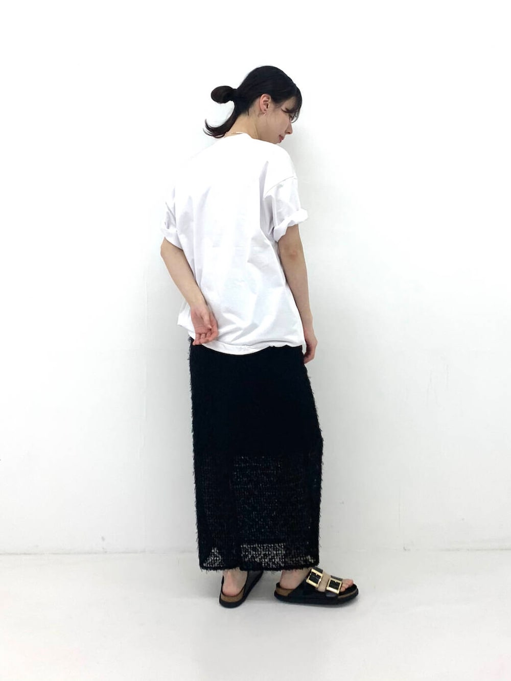 ホワイト系のTシャツ/カットソー、ブラック系のスカート、ブラック系のサンダルを着用したレディースの夏コーディネートの2枚目の写真