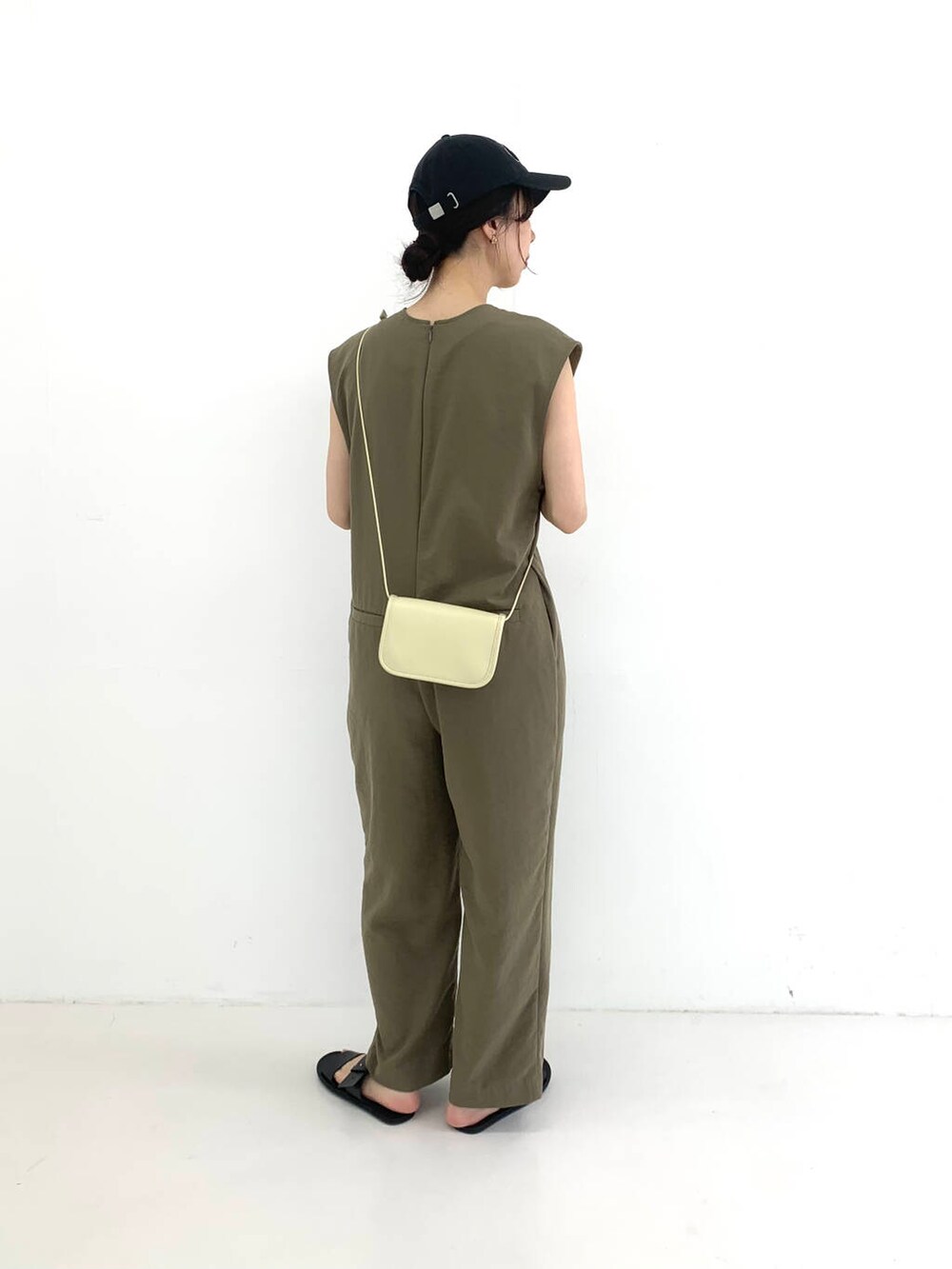 ホワイト系のショルダーバッグ、ブラック系のサンダル、グリーン系のサロペット/オーバーオールを着用したレディースの夏コーディネートの2枚目の写真