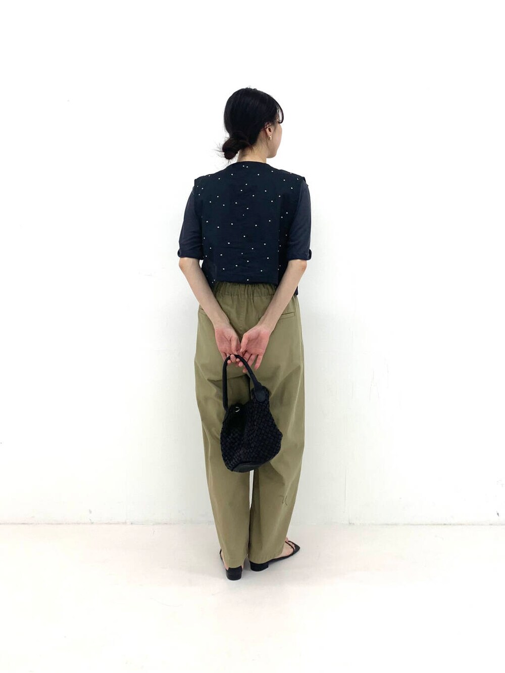 ブラック系のベスト、ブラック系のトートバッグ、ベージュ系のその他パンツを着用したレディースの夏コーディネートの3枚目の写真