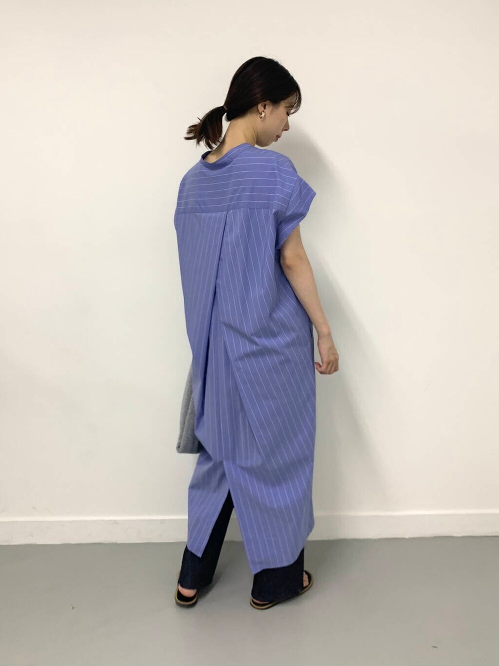 シルバー系のトートバッグ、ブルー系のワンピース、ブルー系のデニムパンツを着用したレディースの夏コーディネートの2枚目の写真