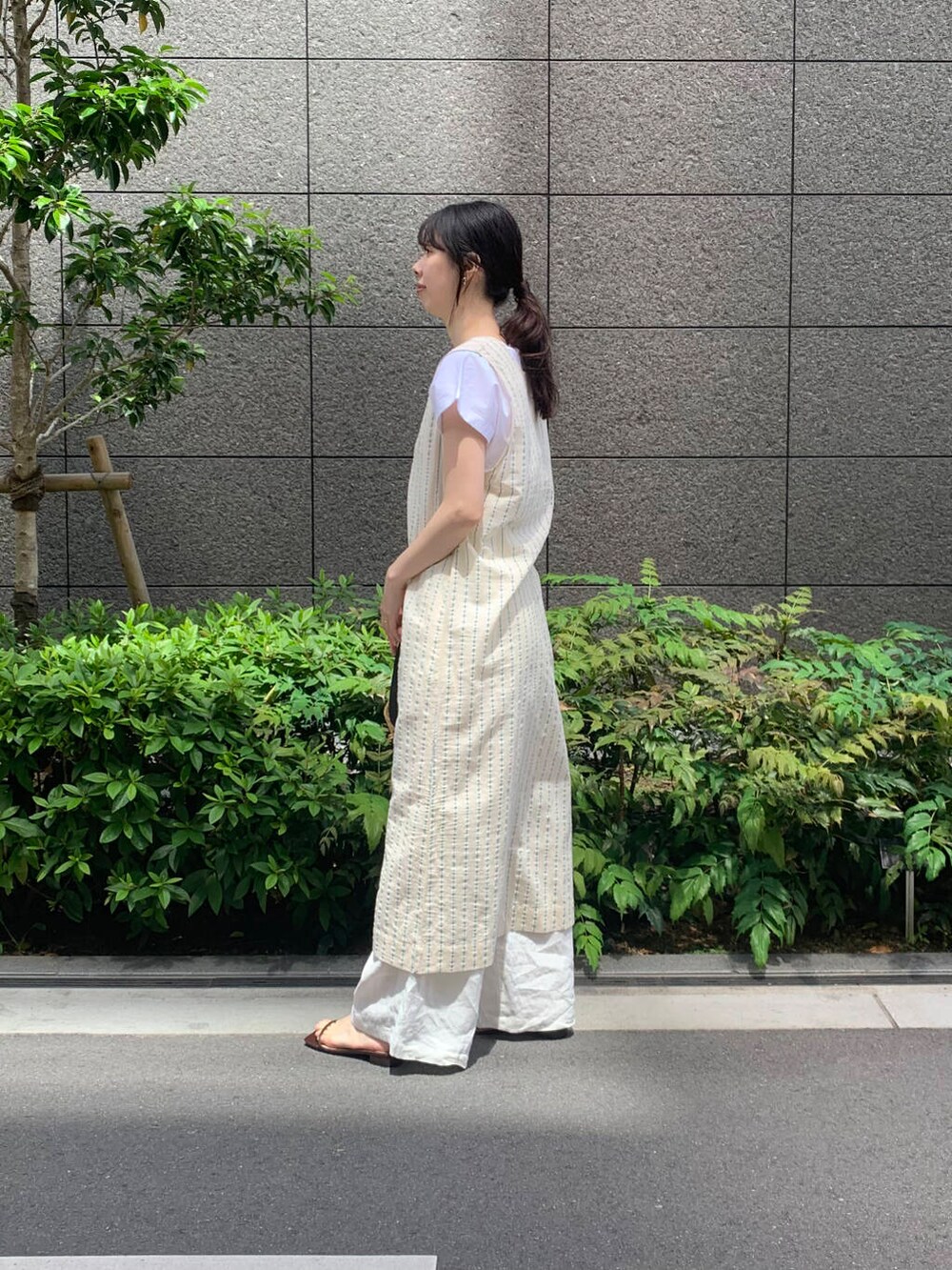 ベージュ系のワンピース、ホワイト系のその他パンツ、ブラウン系のサンダルを着用したレディースの春コーディネートの2枚目の写真