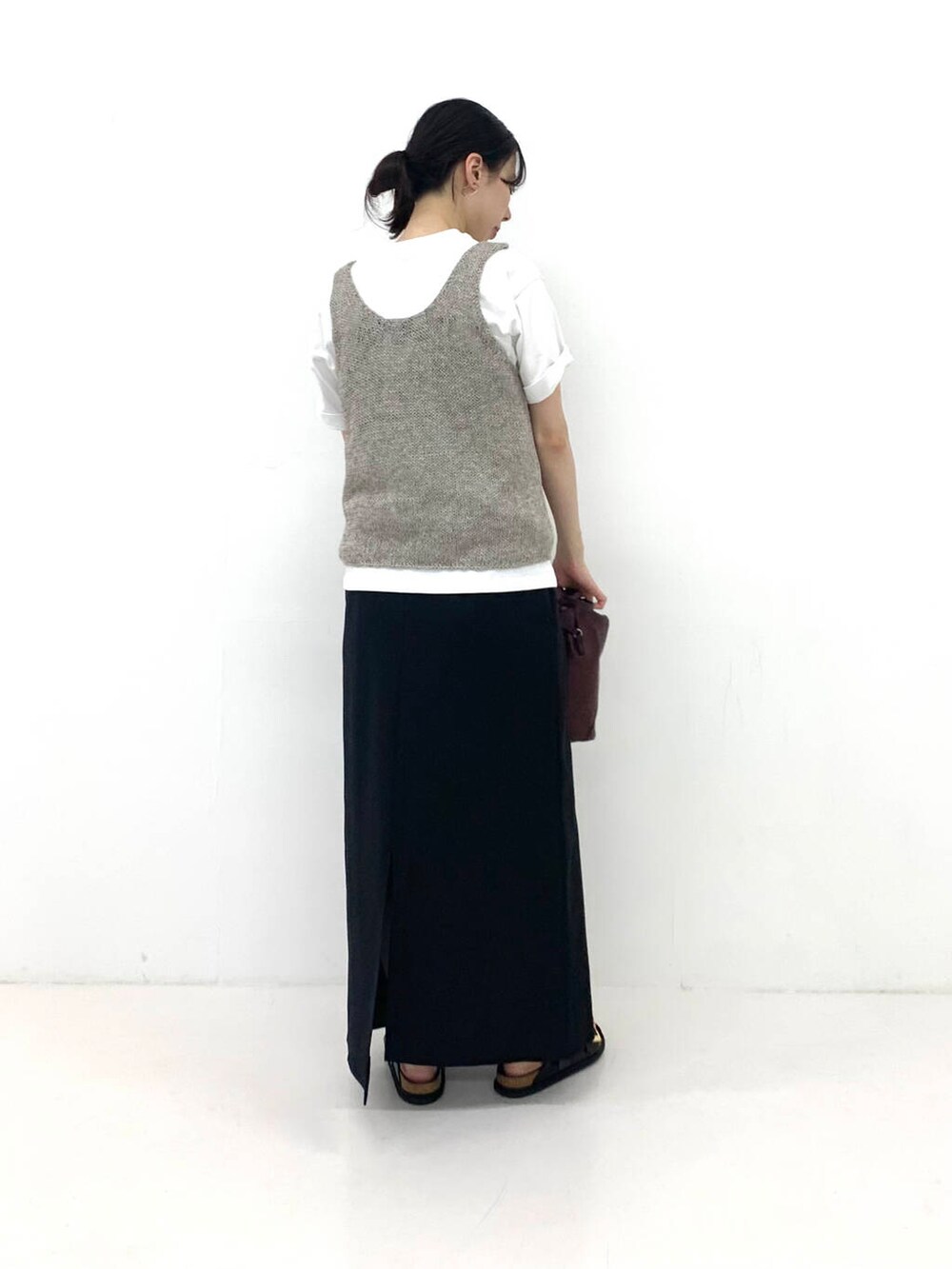 ブラック系のスカート、グレー系のニット/セーターを着用したレディースの夏コーディネートの3枚目の写真