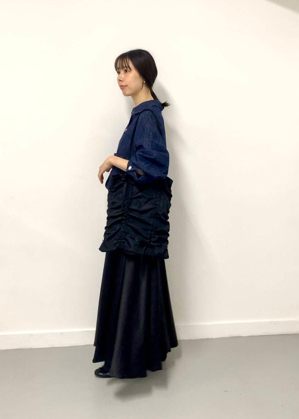 ブラック系のトートバッグ、ブルー系のデニムジャケットを着用したレディースの夏コーディネートの2枚目の写真