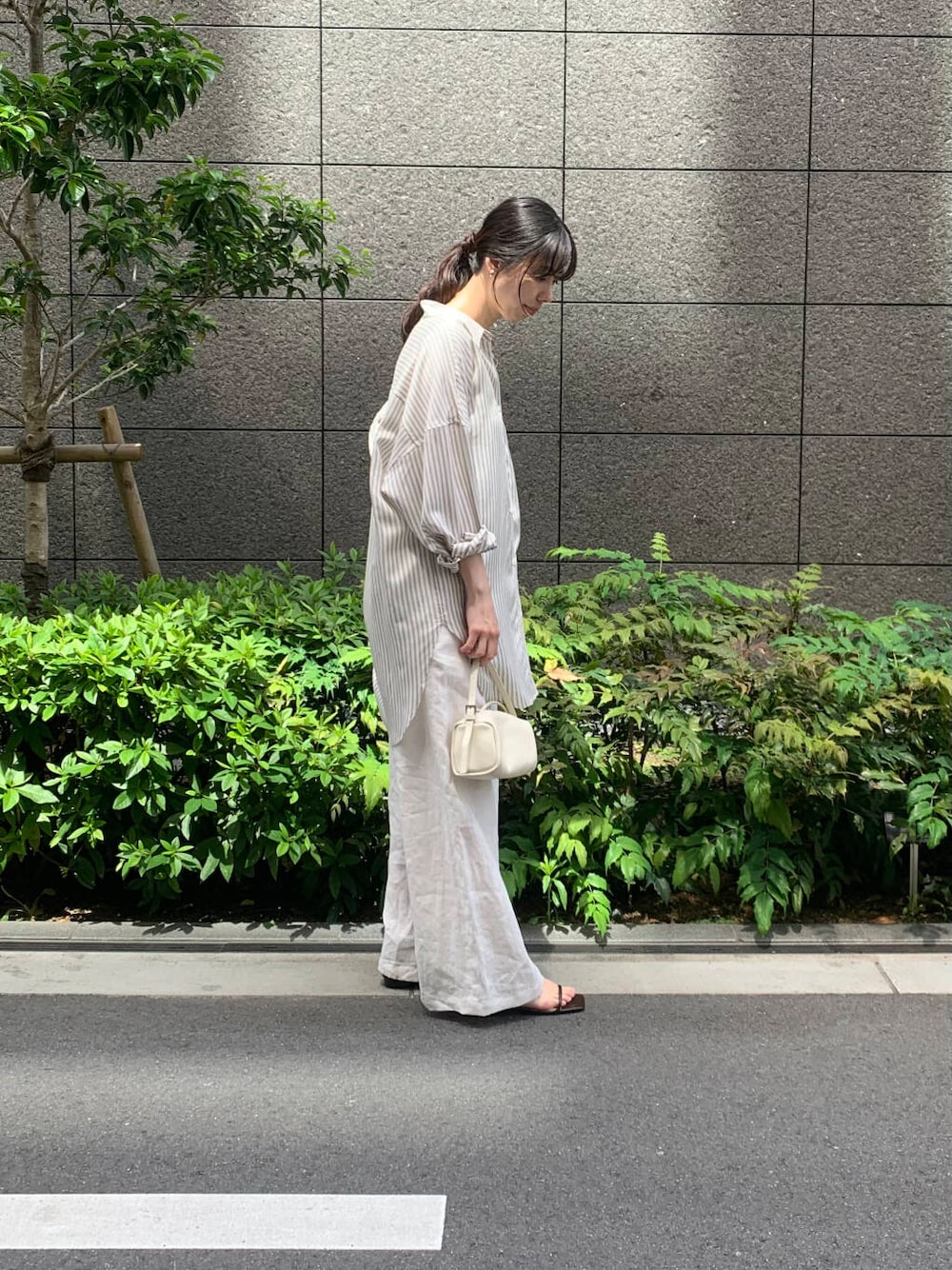 ホワイト系のキャミソール、ホワイト系のその他パンツ、ホワイト系のショルダーバッグを着用したレディースの春コーディネートの3枚目の写真