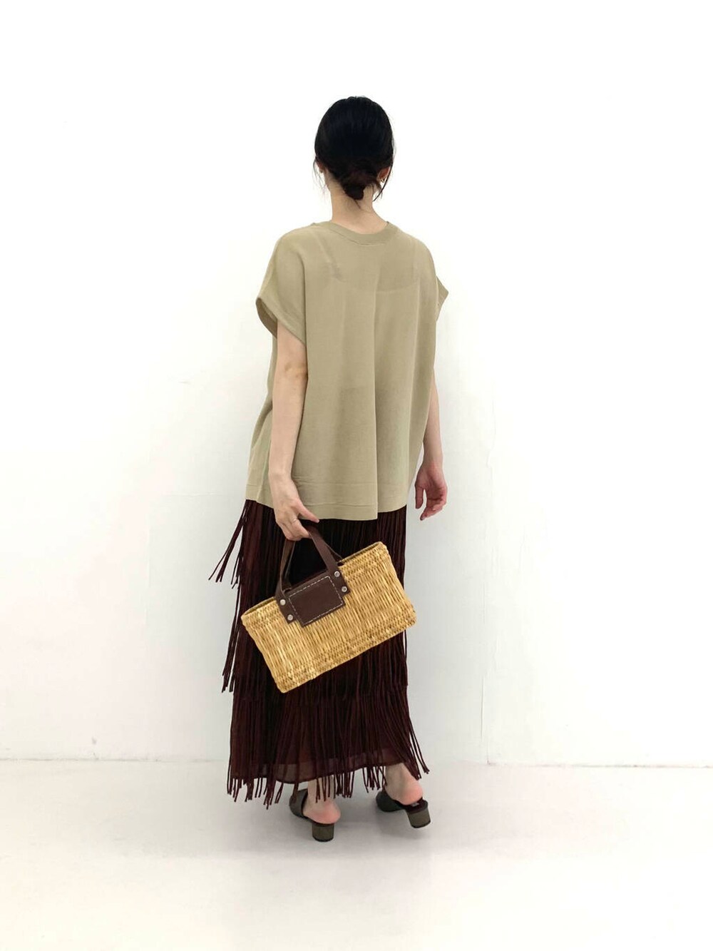 ブラウン系のかごバッグ、ブラウン系のサンダル、ブラウン系のスカートを着用したレディースの夏コーディネートの2枚目の写真