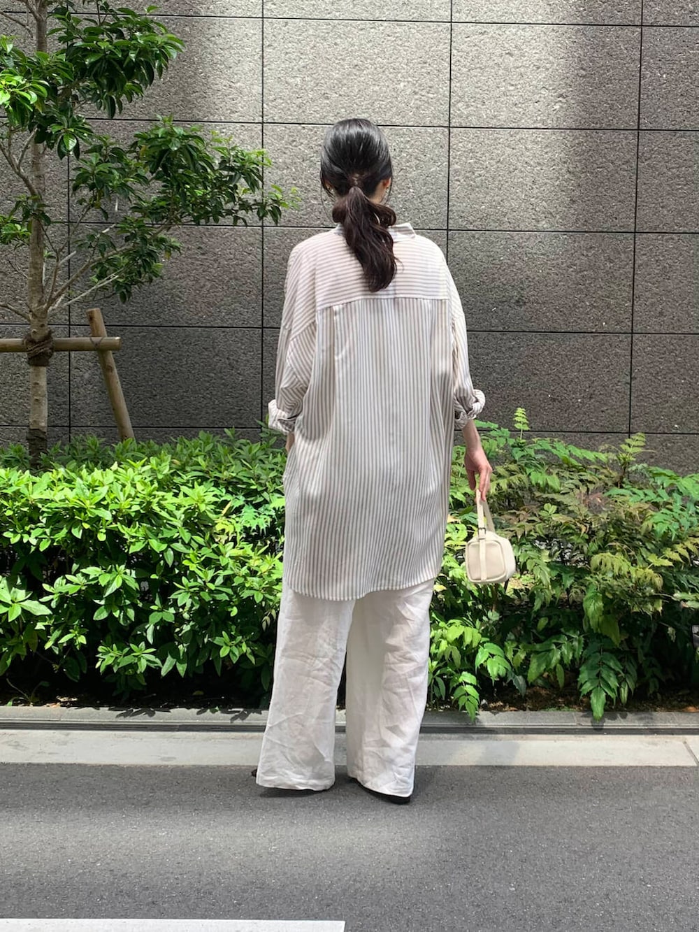 ホワイト系のキャミソール、ホワイト系のその他パンツ、ホワイト系のショルダーバッグを着用したレディースの春コーディネートの2枚目の写真