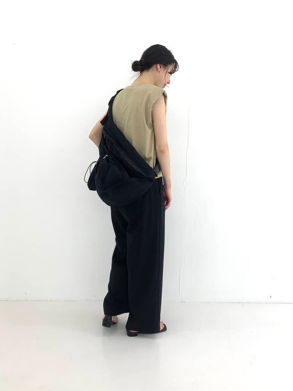 ブラック系のその他パンツ、ブラック系のサンダル、ベージュ系のTシャツ/カットソーを着用したレディースの夏コーディネートの3枚目の写真