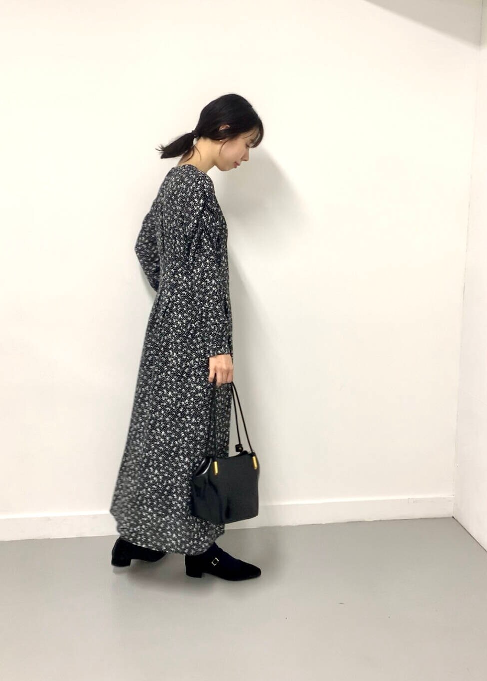 ブラック系のトートバッグ、ブラック系のワンピース、ブラック系のパンプスを着用したレディースの夏コーディネートの3枚目の写真