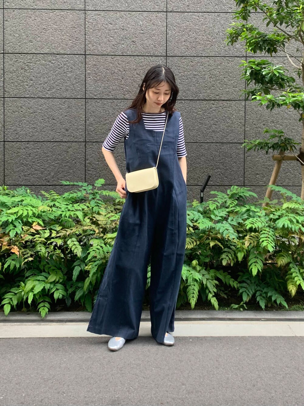 シルバー系のパンプス、ホワイト系のショルダーバッグ、その他のTシャツ/カットソーを着用したレディースの夏コーディネートの2枚目の写真