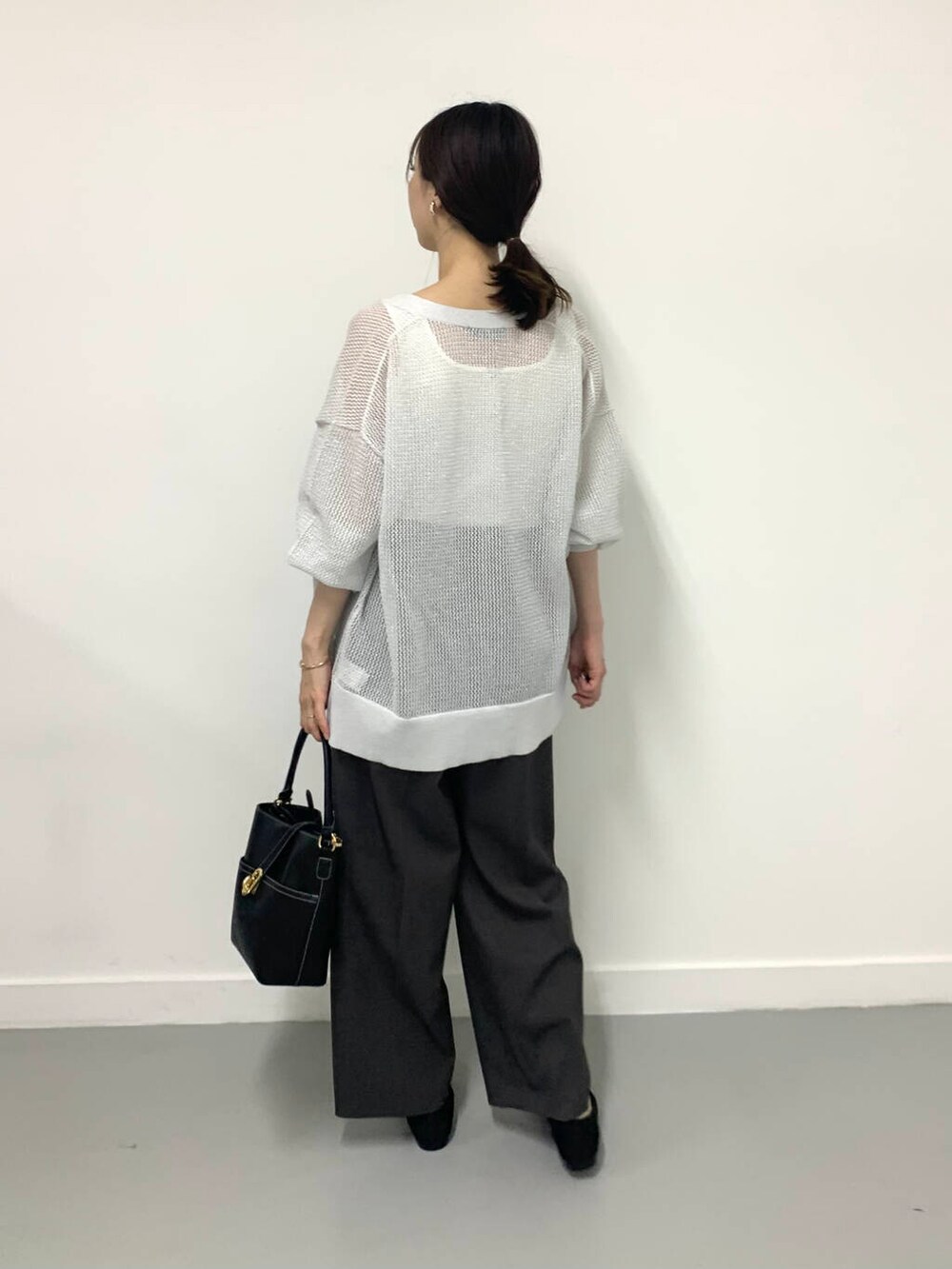 ホワイト系のタンクトップ、ブラック系のハンドバッグ、グレー系のその他パンツを着用したレディースの夏コーディネートの2枚目の写真