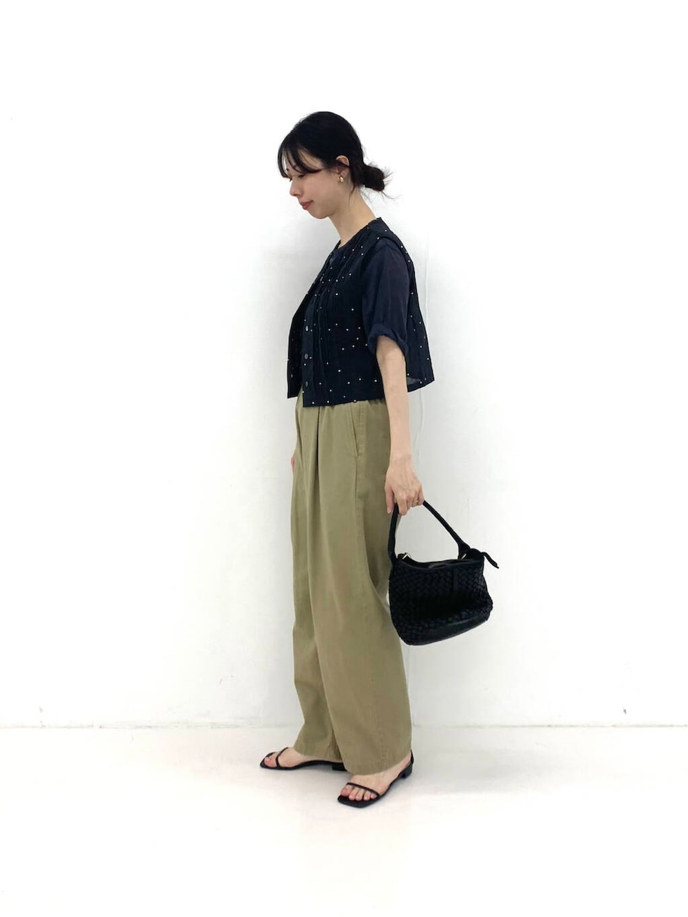 ブラック系のベスト、ブラック系のトートバッグ、ベージュ系のその他パンツを着用したレディースの夏コーディネートの2枚目の写真