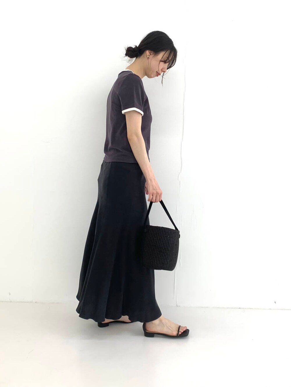 ブラック系のかごバッグ、ブラック系のスカート、ブラック系のサンダルを着用したレディースの夏コーディネートの3枚目の写真