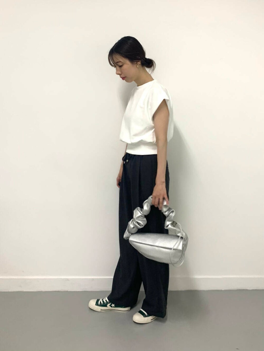 グリーン系のスニーカー、シルバー系のハンドバッグ、グレー系のその他パンツを着用したレディースの夏コーディネートの2枚目の写真