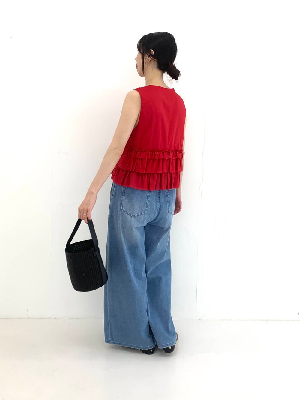 ブラック系のかごバッグ、レッド系のシャツ/ブラウス、ブルー系のデニムパンツを着用したレディースの夏コーディネートの2枚目の写真