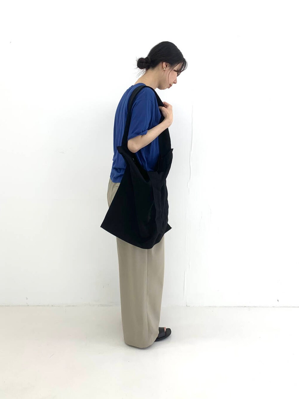 ベージュ系のその他パンツ、ブラック系のサンダル、ブルー系のTシャツ/カットソーを着用したレディースの夏コーディネートの3枚目の写真