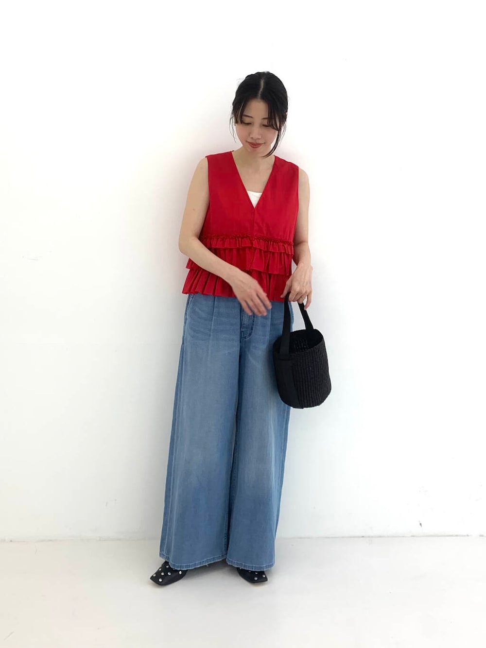 ブラック系のかごバッグ、レッド系のシャツ/ブラウス、ブルー系のデニムパンツを着用したレディースの夏コーディネートの4枚目の写真