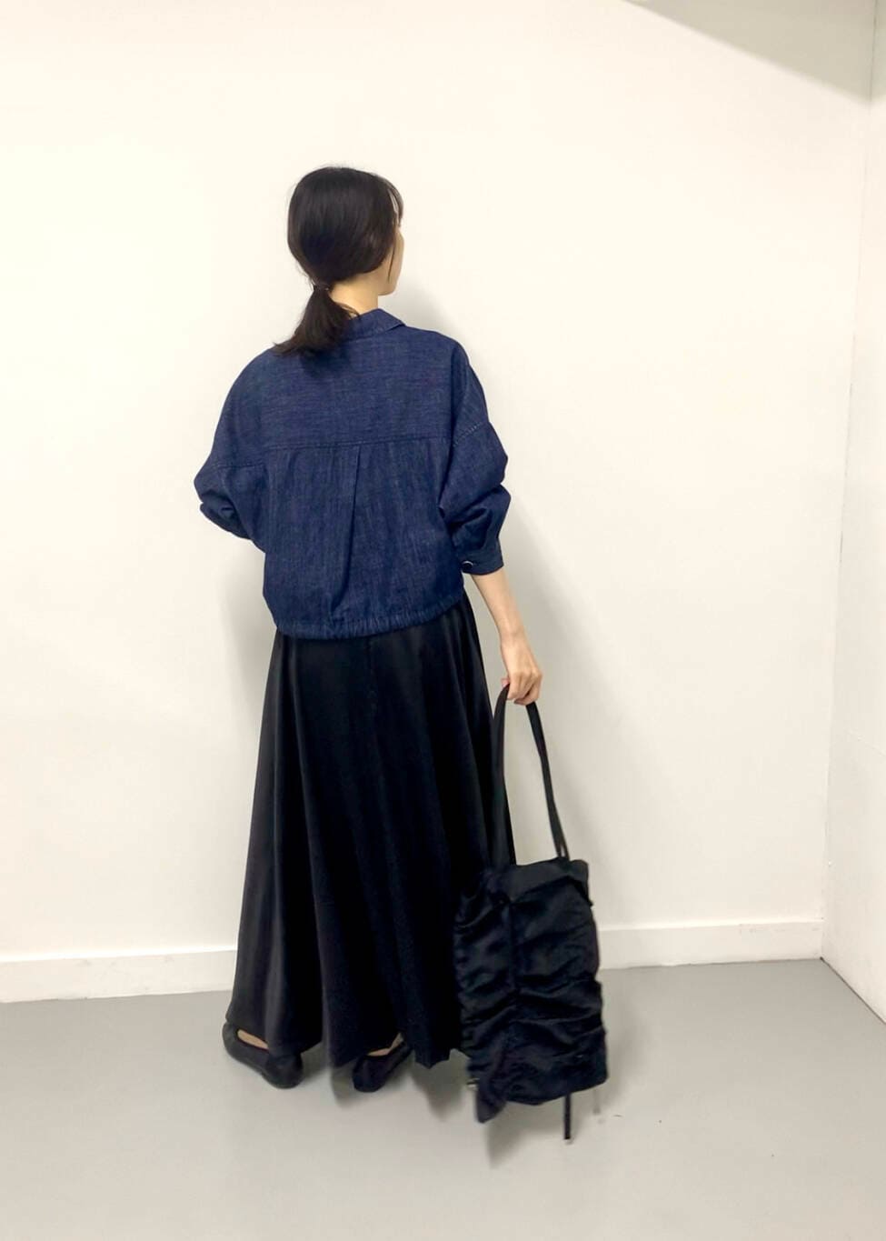 ブラック系のトートバッグ、ブルー系のデニムジャケットを着用したレディースの夏コーディネートの3枚目の写真