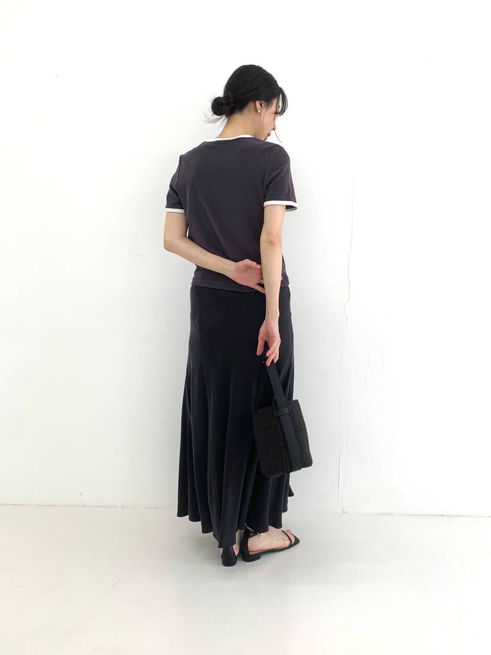 ブラック系のかごバッグ、ブラック系のスカート、ブラック系のサンダルを着用したレディースの夏コーディネートの2枚目の写真