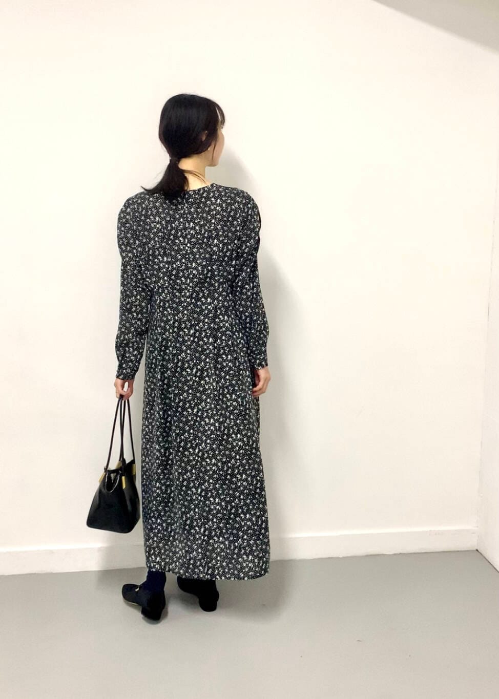 ブラック系のトートバッグ、ブラック系のワンピース、ブラック系のパンプスを着用したレディースの夏コーディネートの2枚目の写真