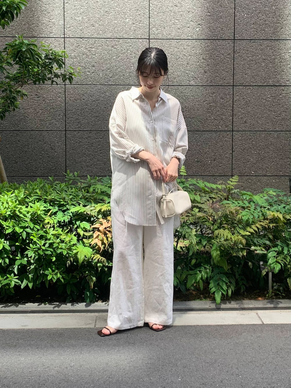 ホワイト系のキャミソール、ホワイト系のその他パンツ、ホワイト系のショルダーバッグを着用したレディースの春コーディネートの4枚目の写真