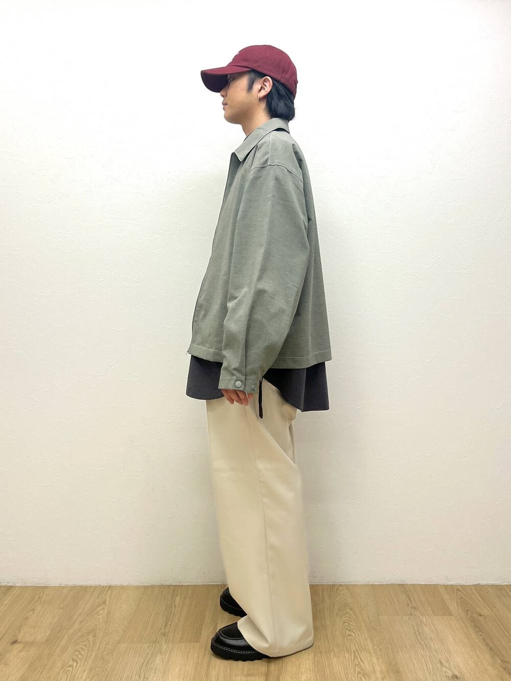 グレー系のシャツ/ブラウス、ブラック系のドレスシューズ、ホワイト系のスラックスを着用したメンズの春コーディネートの2枚目の写真