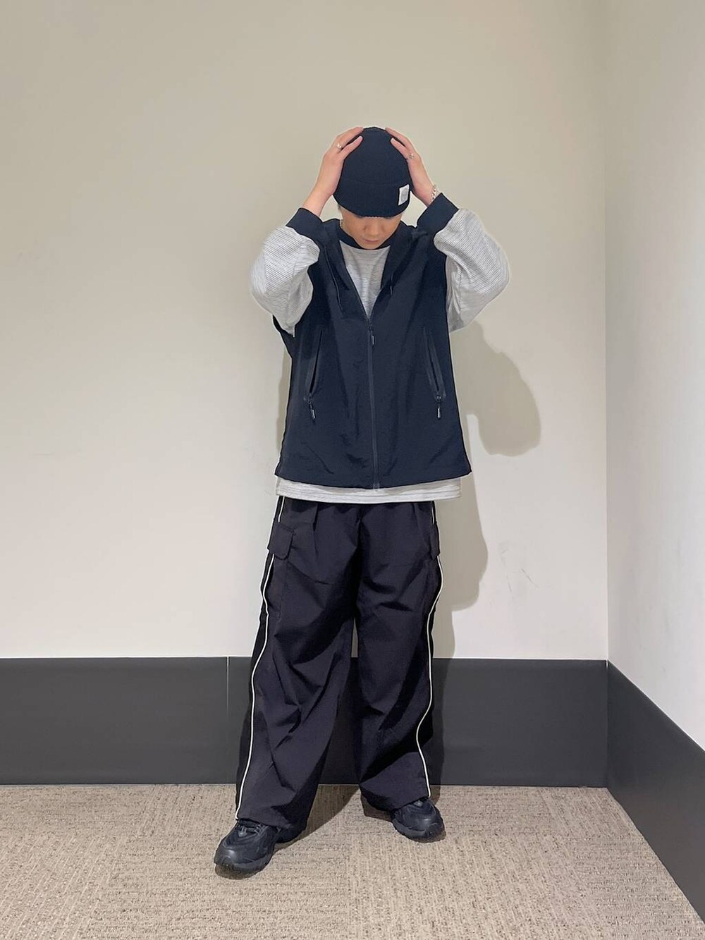 ブラック系のスニーカー、ブラック系のカーゴパンツ、ホワイト系のTシャツ/カットソーを着用したメンズの秋コーディネートの2枚目の写真