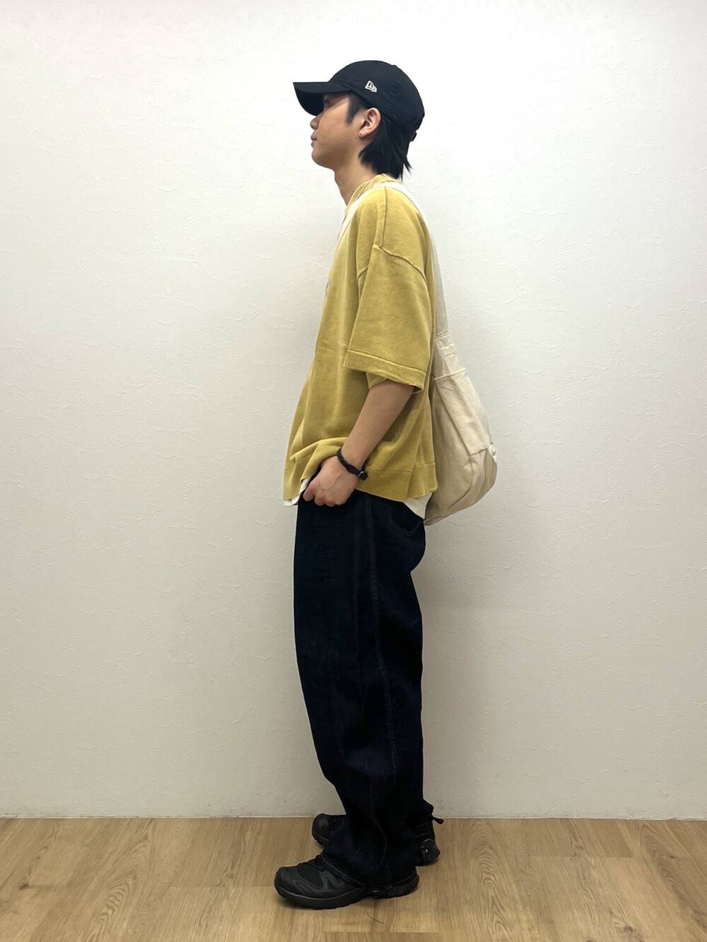 ブラック系のスニーカー、イエロー系のTシャツ/カットソー、ブルー系のデニムパンツを着用したメンズの春コーディネートの2枚目の写真