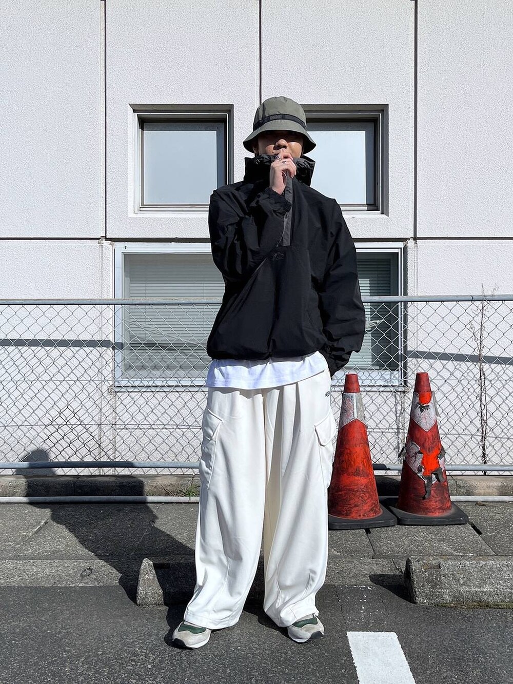 ホワイト系のカーゴパンツ、ブラック系のブルゾン、グリーン系のハットを着用したメンズの秋コーディネートの4枚目の写真