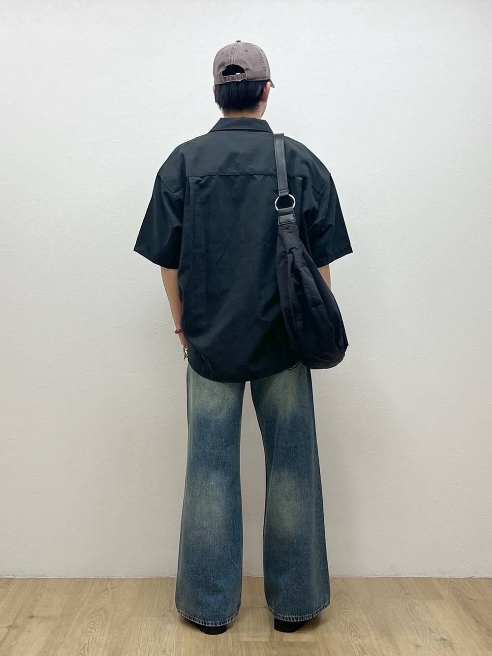 ブルー系のデニムパンツ、ブラック系のドレスシューズ、ホワイト系のTシャツ/カットソーを着用したメンズの夏コーディネートの3枚目の写真