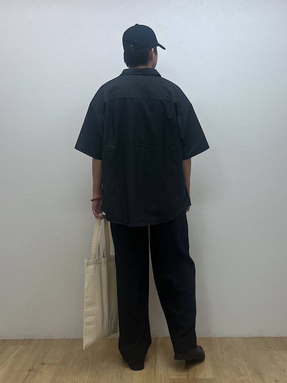 ホワイト系のトートバッグ、ホワイト系のTシャツ/カットソー、ブラック系のシャツ/ブラウスを着用したメンズの夏コーディネートの3枚目の写真