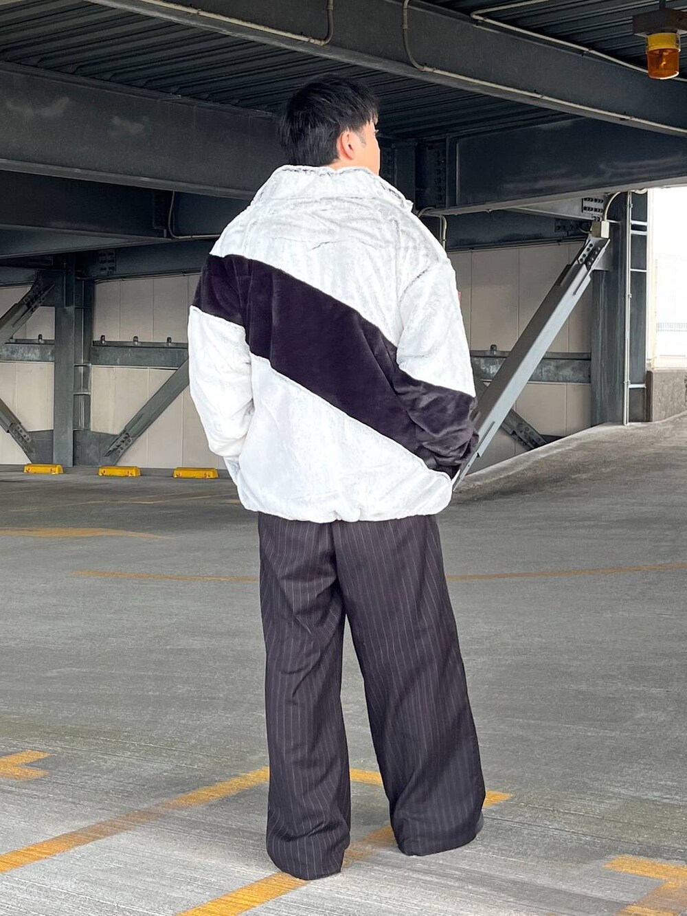 ブラック系のスラックス、グレー系のブルゾン、ブラック系のスウェットを着用したメンズの冬コーディネートの3枚目の写真