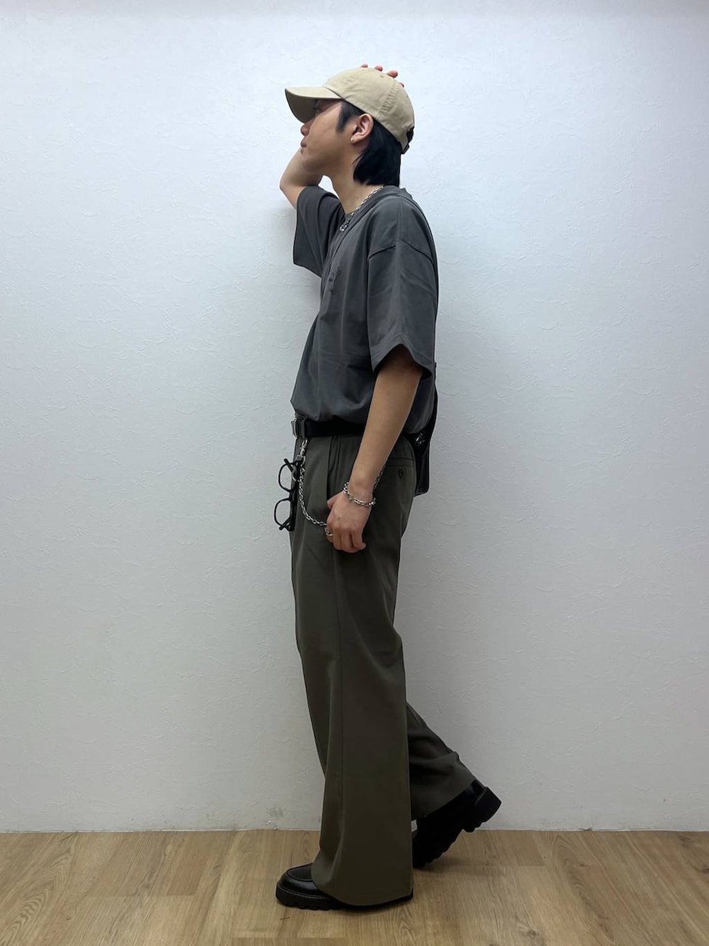 ブラック系のドレスシューズ、ベージュ系のスラックス、グレー系のTシャツ/カットソーを着用したメンズの春コーディネートの2枚目の写真